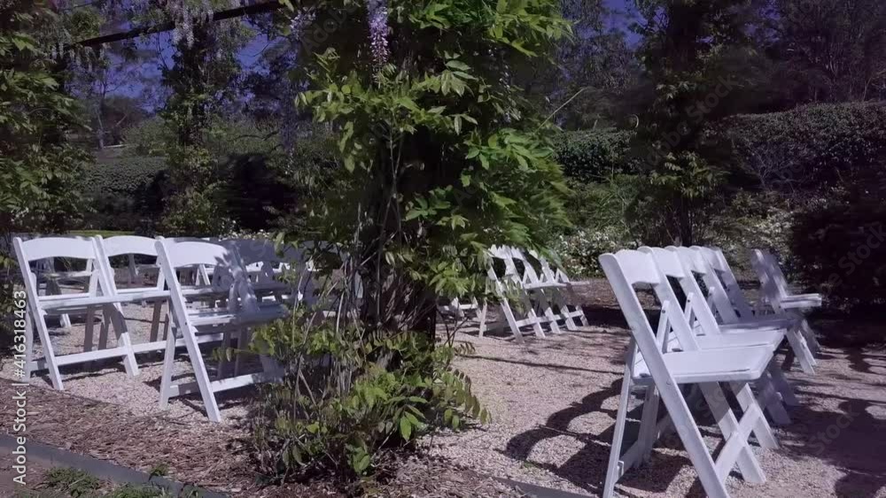 White Chairs Arranged In Rows In A Garden Wedding Venue. drone shot White Chairs Arranged In Rows In A Garden Wedding Venue. drone shot
