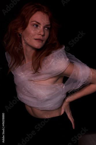 portrait of a ginger woman in white top