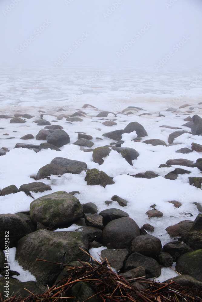 foggy beach with rocks in snow and ice at winter foggy beach with rocks in snow and ice at winter
