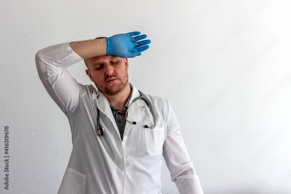 Tired Caucasian doctor or male nurse in white uniform and face medical mask for protection from virus disease isolated on white background. Exhausted doctor in uniform. Healthcare and medicine concept Tired Caucasian doctor or male nurse in white uniform and face medical mask for protection from virus disease isolated on white background. Exhausted doctor in uniform. Healthcare and medicine concept