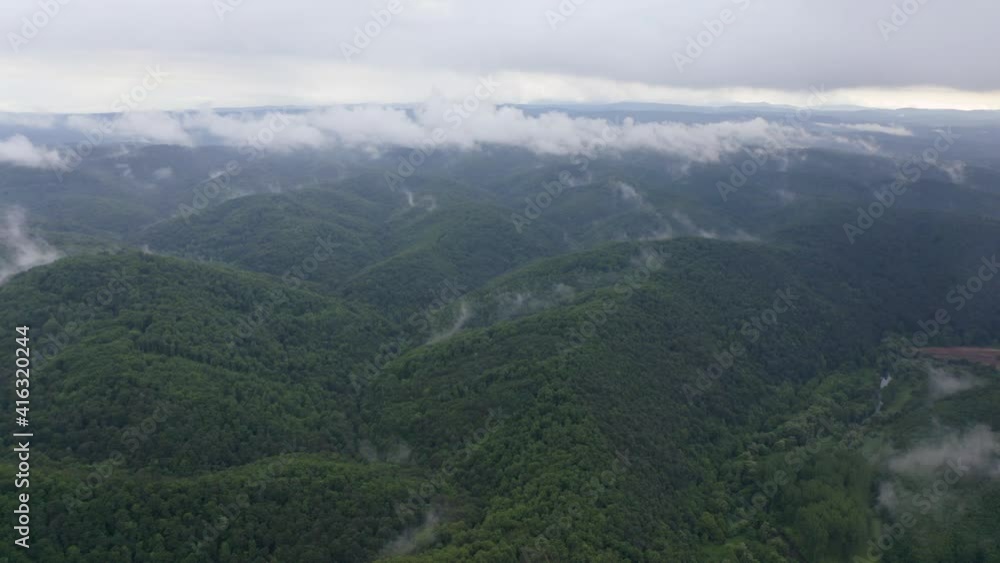 Drone flight over green mountain slopes with creeping spring mists above them, Strandzha Mountain, Bulgaria Drone flight over green mountain slopes with creeping spring mists above them, Strandzha Mountain, Bulgaria