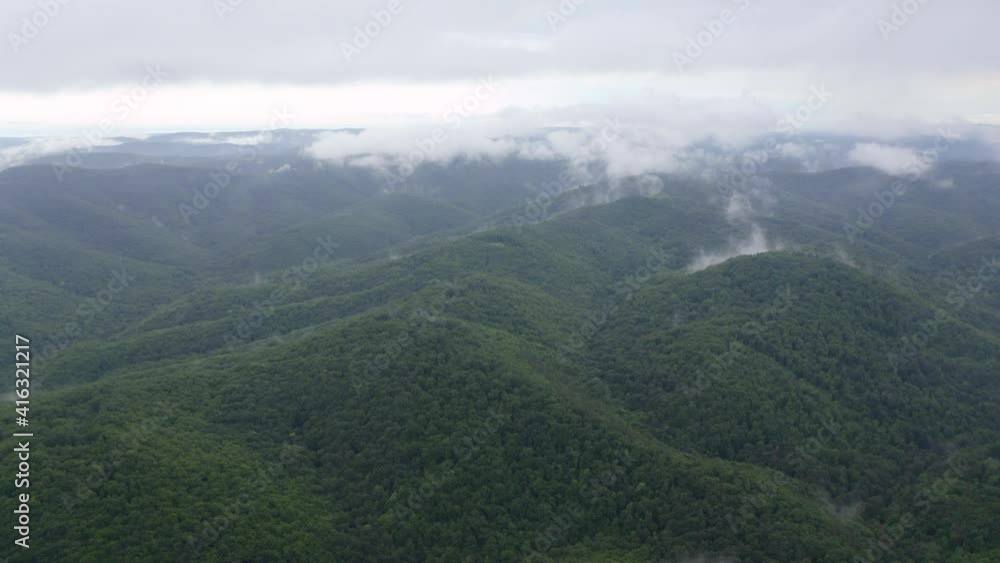 Drone flight over green mountain slopes with creeping spring mists above them, Strandzha Mountain, Bulgaria Drone flight over green mountain slopes with creeping spring mists above them, Strandzha Mountain, Bulgaria