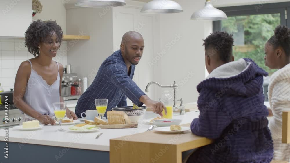 Mother Hands Plate of Toast to Young Daughter During Family Breakfast Mother Hands Plate of Toast to Young Daughter During Family Breakfast