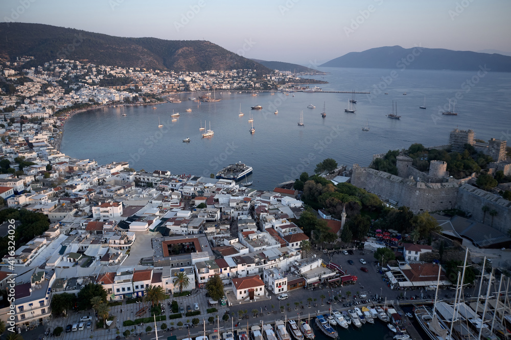 Panoramic view of resort town of Bodrum, Turkey. Aerial drone view of Aegean sea with boats, architecture of Bodrum town and Medieval castle of Saint Peter.