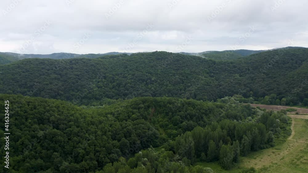 Drone flight over green mountain slopes with creeping spring mists above them, Strandzha Mountain, Bulgaria Drone flight over green mountain slopes with creeping spring mists above them, Strandzha Mountain, Bulgaria