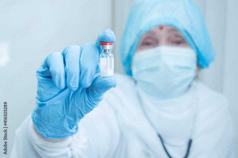 Indian doctor, nurse, scientist hand in blue gloves holding injection vial. Flu, measles, coronavirus, covid-19 vaccine disease. Immunization. Global vaccination. Indian vaccine. Health people Indian doctor, nurse, scientist hand in blue gloves holding injection vial. Flu, measles, coronavirus, covid-19 vaccine disease. Immunization. Global vaccination. Indian vaccine. Health people