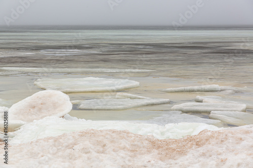 Sea view with frozen water, ice cubes and snow in foreground at the Baltic sea in February in Latvia