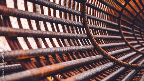 Iron on construction site. Circle Iron Bundle for making reinforcement concrete and plastic orange net. Inside view of rebar for reinforced hole in the ground. Texture