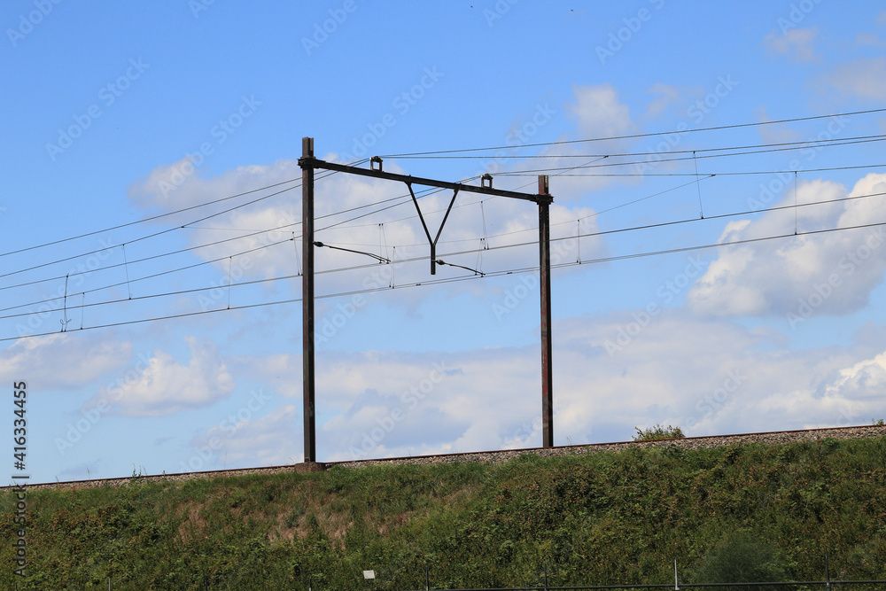 Fototapeta premium Embankment with catenary, blue sky in the background 