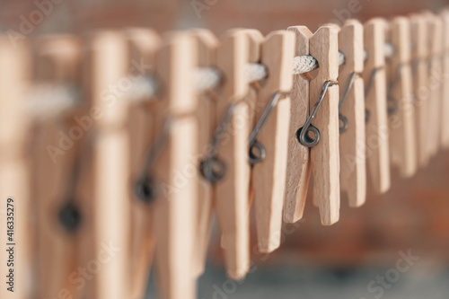Wooden clothespins on a rope. Selective focus on one clothespin. Copy, empty space for text