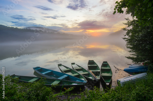 Fototapeta Naklejka Na Ścianę i Meble -  green boats on the lake at sunset