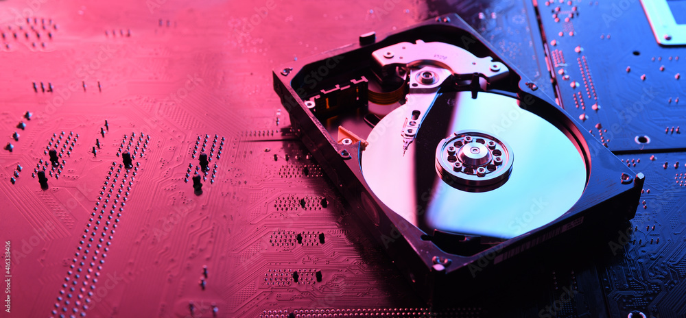 Computer Hard disk drives HDD , SSD on circuit board ,motherboard  background. Close-up. With red-blue lighting Photos | Adobe Stock