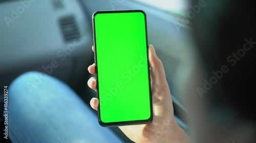 Close up of a woman's hand holding a mobile telephone with a vertical green screen in car chroma key smartphone technology cell phone street touch message display hand