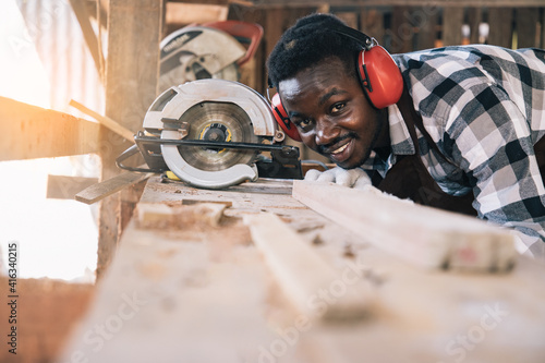 Carpenter man using tools for wood of his own housing at work site. Carpenter makes facade details for construction. housekeeping maintenance concept.