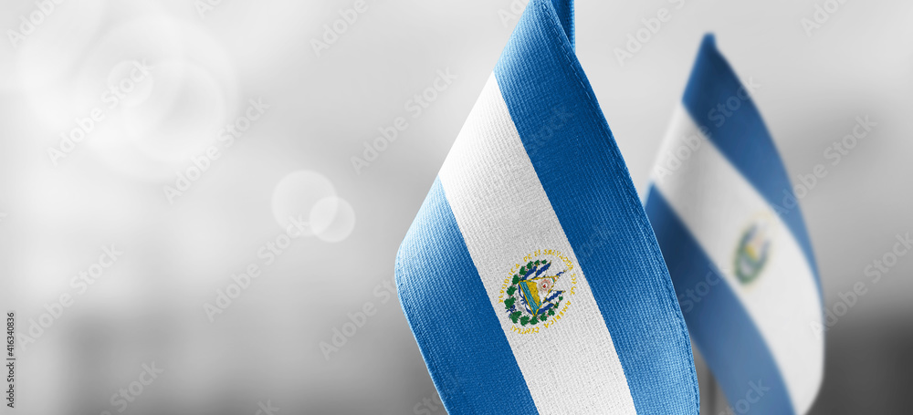 Small national flags of the Salvador on a light blurry background - obrazy, fototapety, plakaty 