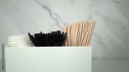 Slow motion angle head on view of beauty treatment products in a white container. White and grey marble background. Beauty salon concept footage.