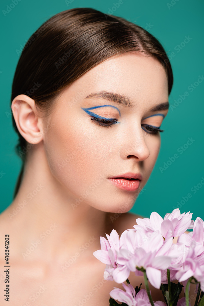 portrait of young sensual woman with creative makeup posing near pink flowers isolated on green portrait of young sensual woman with creative makeup posing near pink flowers isolated on green