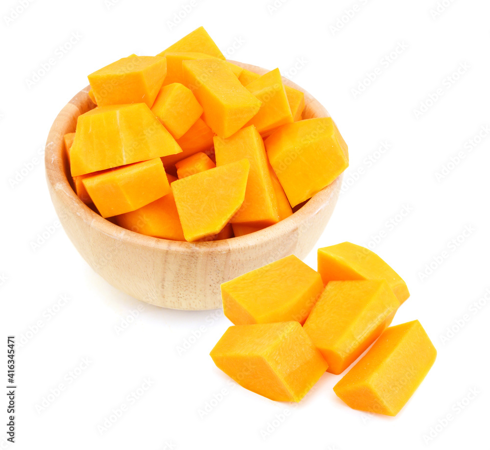 A group of cut and slice butternut squash chunks in wooden bowl and haft squash on a white background. A group of cut and slice butternut squash chunks in wooden bowl and haft squash on a white background.