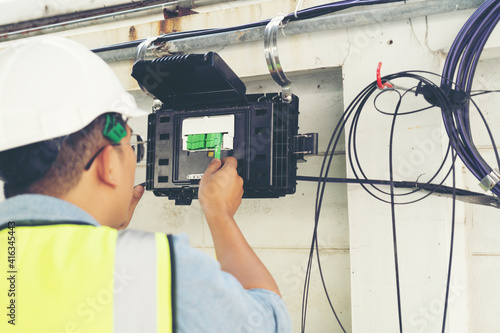 Electrician connecting cable optic fiber of internet network