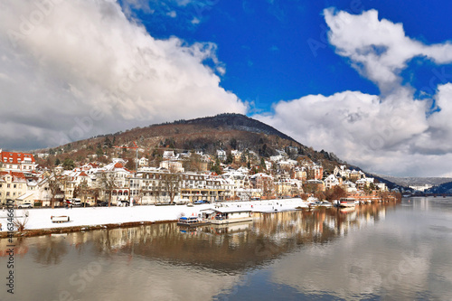 Heidelberg, Germany - Neckar river and Odenwald forest hill called Heiligenberg with historical mansions covered in snow. View from Theodor Heuss bridge on sunny winter day photo