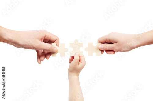 Three hands are holding puzzles on a white background. Help of a psychologist in family problems.