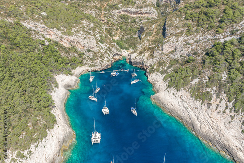 Aerial drone shot of yachts at Stiniva cove of blue Adriatic sea on Vis Island in Croatia summer