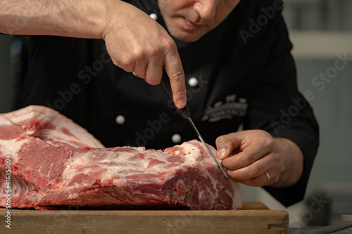 Fotografie butcher processes the meat in the butchery