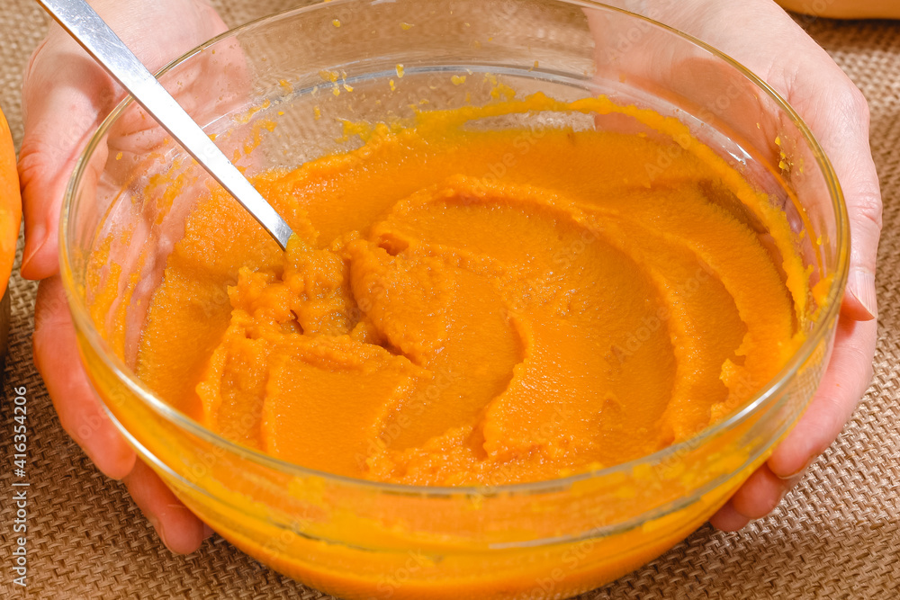 Fresh pumpkin puree in a glass bowl close up on rustic background. Making pumpkin puree from scratch Fresh pumpkin puree in a glass bowl close up on rustic background. Making pumpkin puree from scratch
