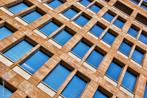 Wall pattern of brown stone and wood structure with windows 