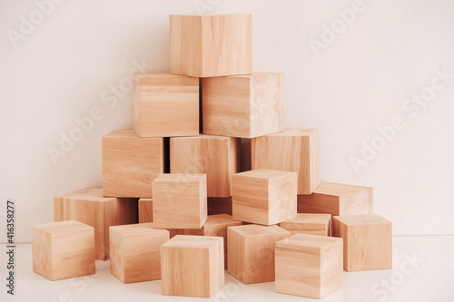 Pyramid of wooden blocks from natural wood on a white background. Copy  empty space for text