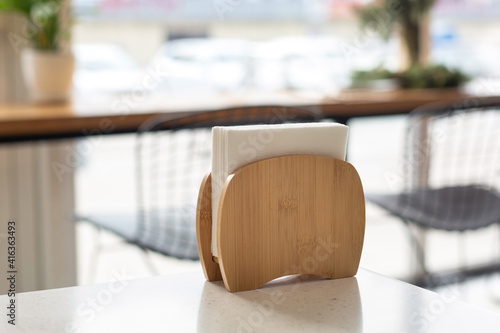Wooden stand for paper napkins on a table in a cafe. Restaurant service.