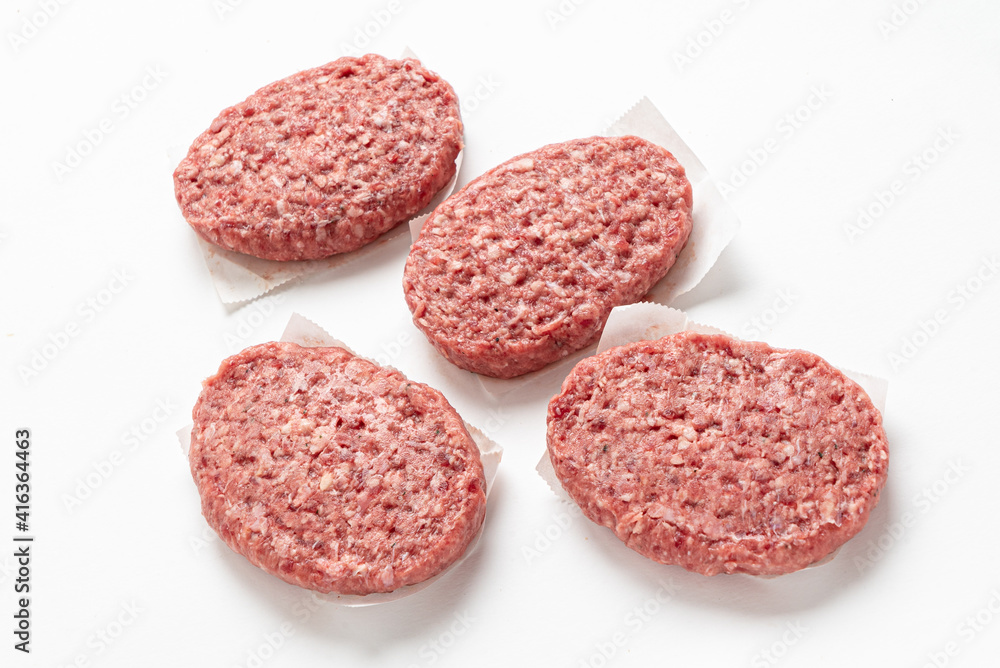 Raw minced homemade cutlets, on the white background Raw minced homemade cutlets, on the white background