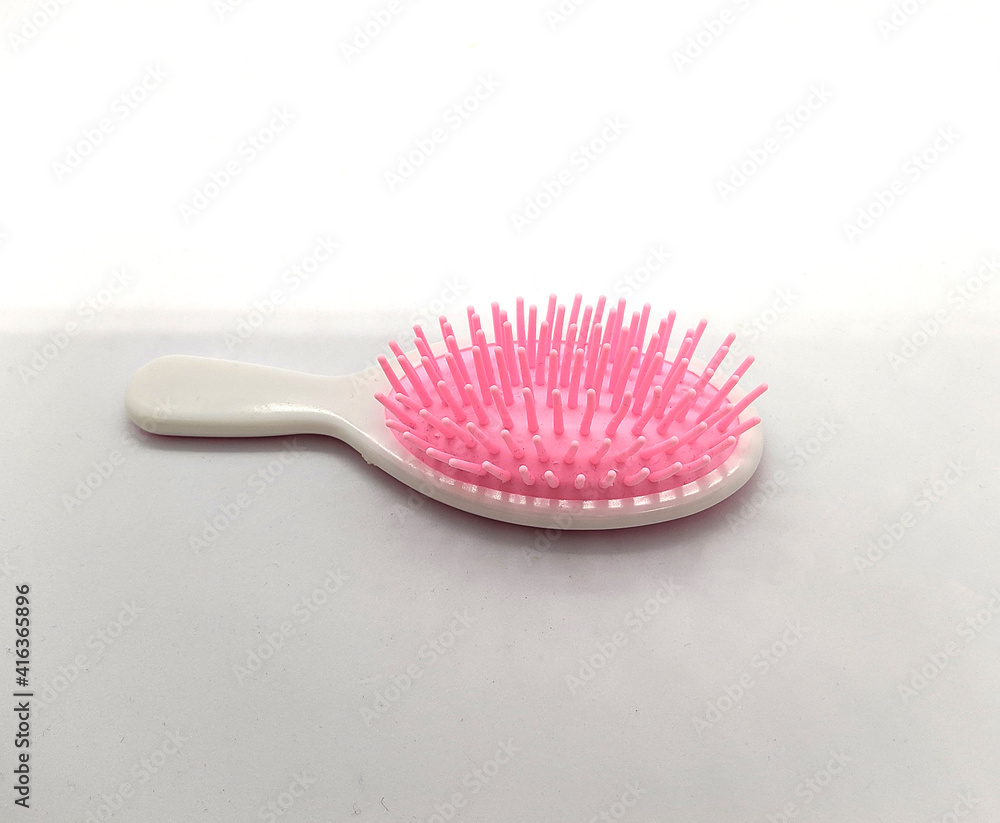baby pink and white comb on a white background baby pink and white comb on a white background