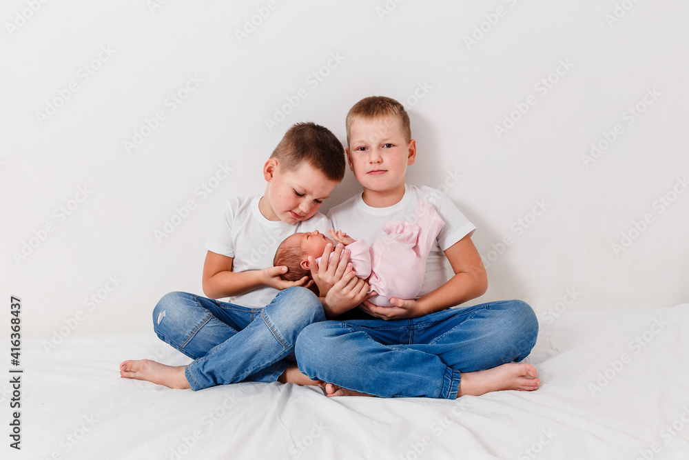 two seven-year-old boys keep only born girl on white background two seven-year-old boys keep only born girl on white background