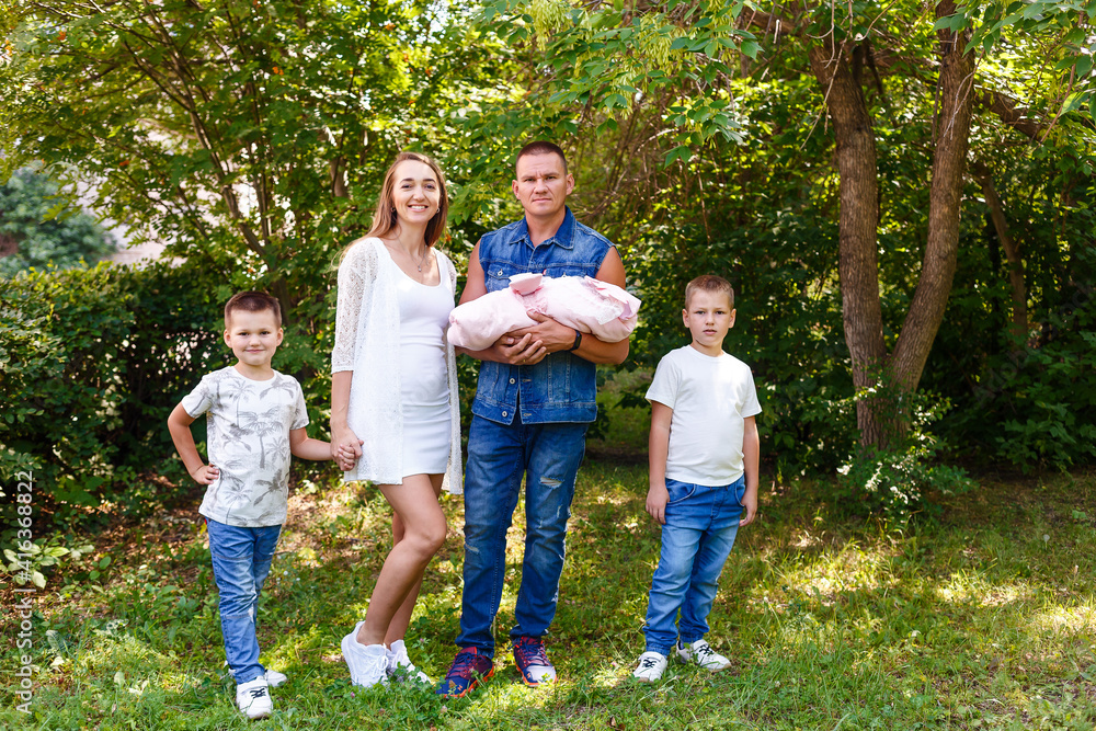 Fototapeta premium Happy family with newborn baby on natural green background