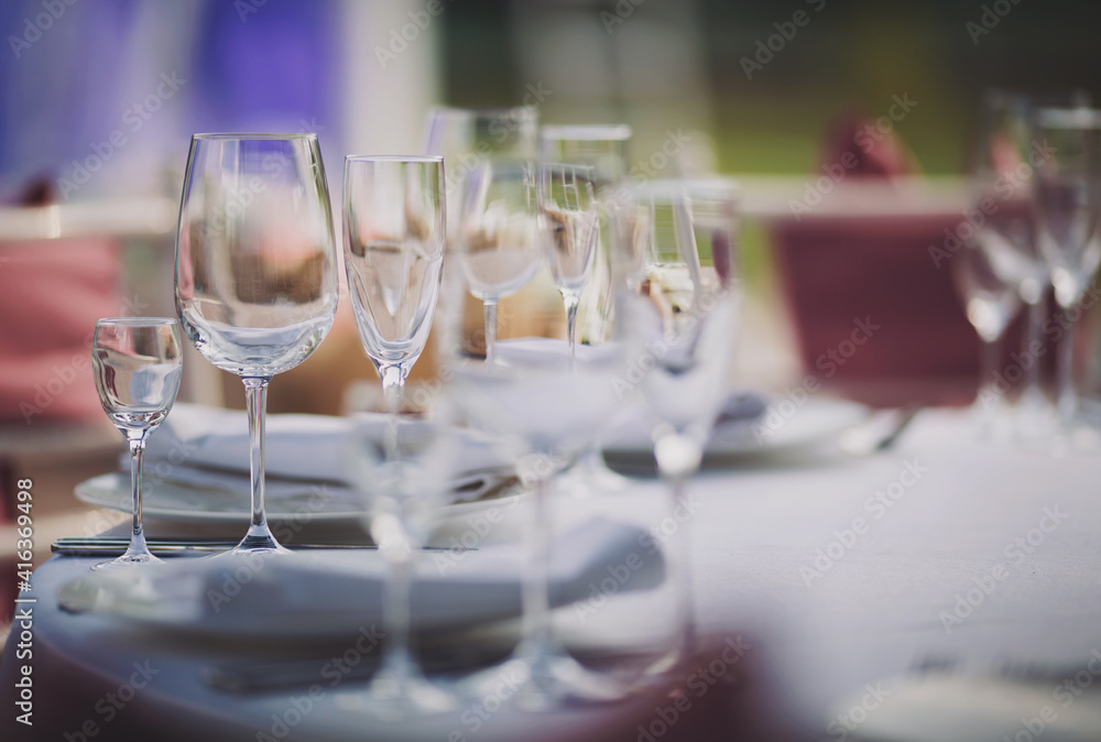 Elegant dinner table setting in restaurant or hotel with wine glasses