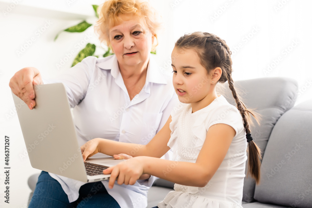 modern grandmother teaching grandchild how to use laptop computer at home modern grandmother teaching grandchild how to use laptop computer at home