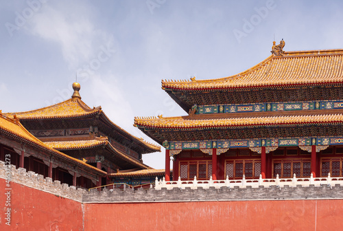 Beijing, China - April 27, 2010: Forbidden City. Meridain Gate corner and other buildings seen over red wall under blue sky. Chinese architecture.