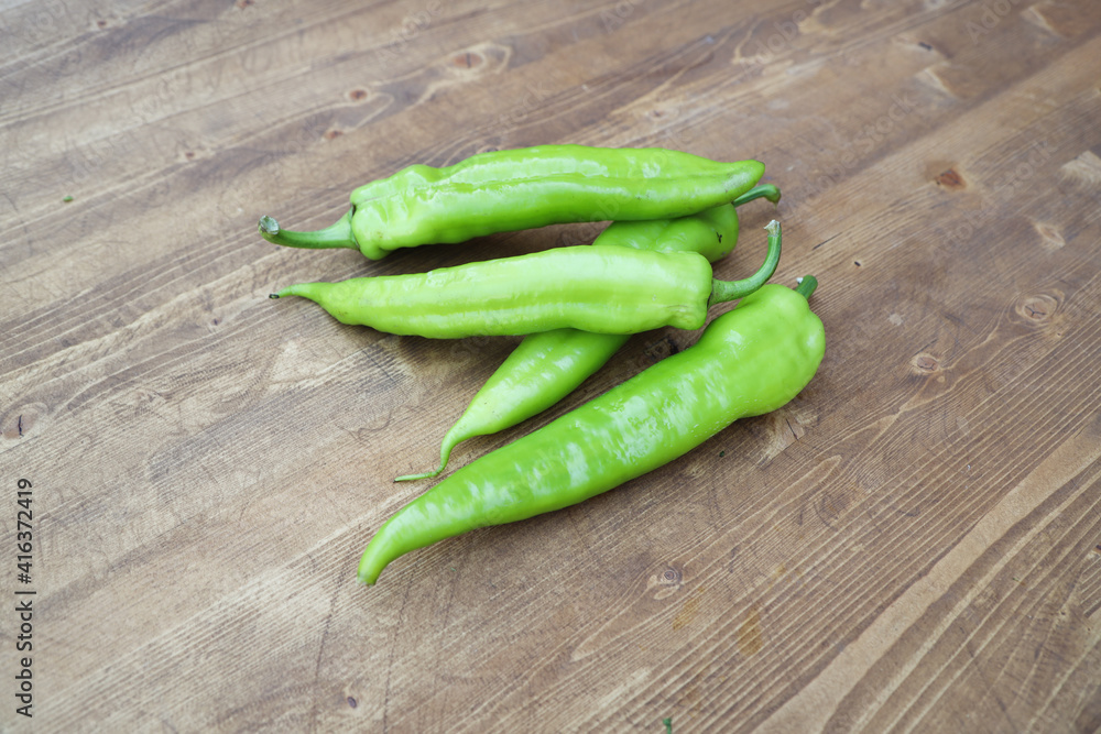 green pepper pods on a wooden table green pepper pods on a wooden table