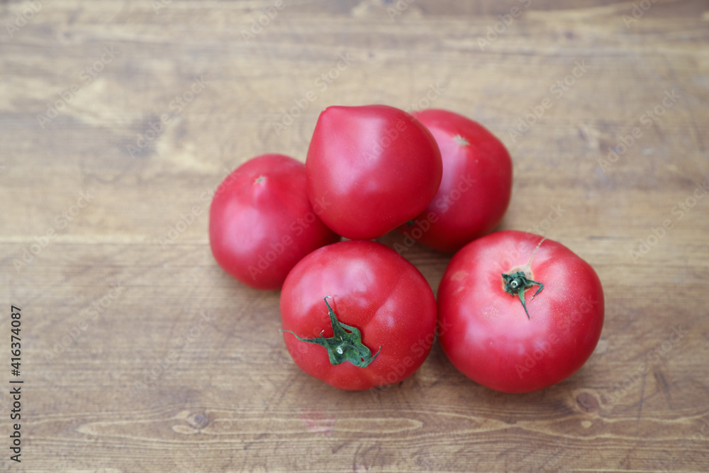 red tomatoes on wooden background red tomatoes on wooden background