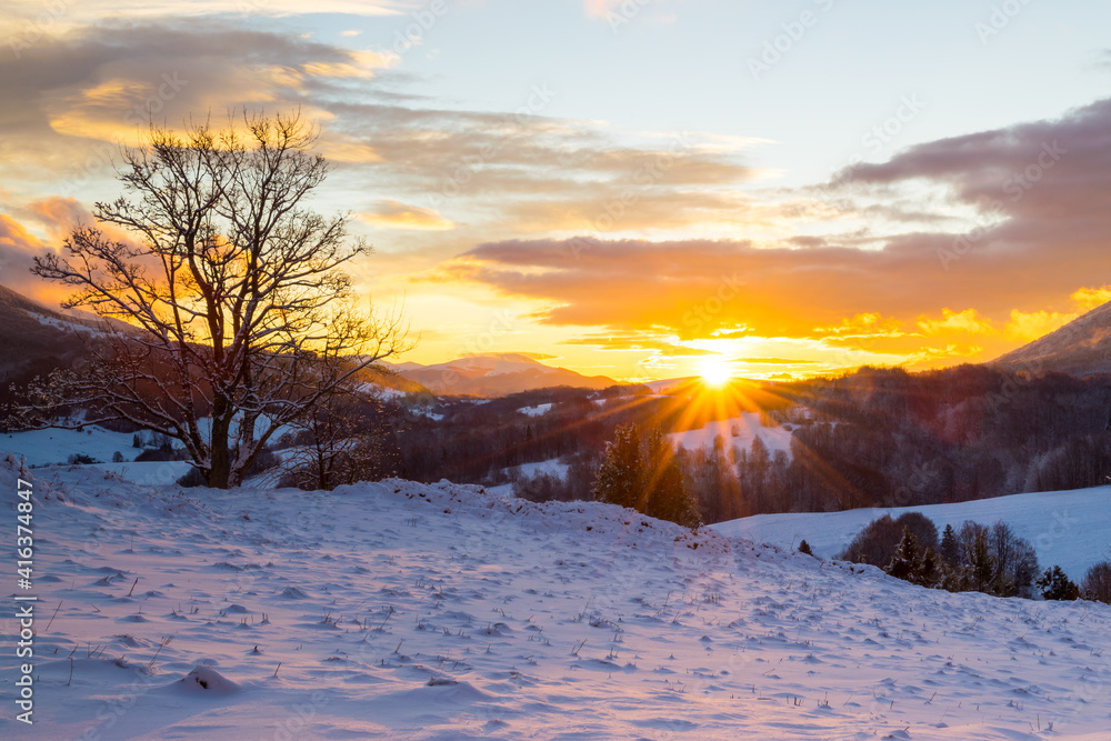 Colorful, winter sunrise in the Bieszczady Mountains, view of snow-covered trees, fields and meadows Colorful, winter sunrise in the Bieszczady Mountains, view of snow-covered trees, fields and meadows