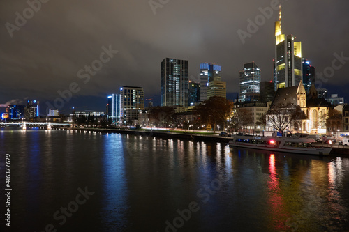 Blick vom Mainufer auf die nächtliche Skyline von Frankfurt
