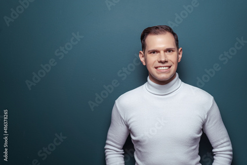 Studio portrait of happy handsome young man on blue background.