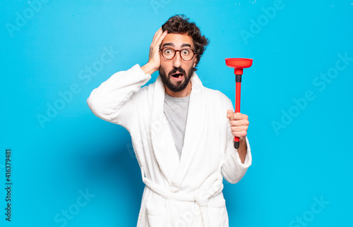 young bearded man wearing bathrobe with a plunger photo