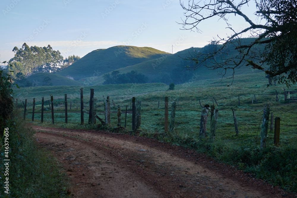 Lehmstrasse durch Weideland im südlichen Brasilien am frühen Morgen