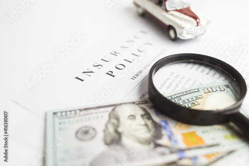 Certificate of motor insurance and policy with car and dollar bills