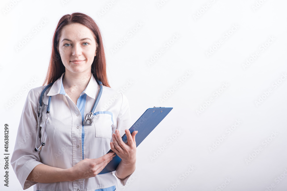 Portrait of a young female doctor in a white uniform with a folder in hands in the studio on a white background with copyspace Portrait of a young female doctor in a white uniform with a folder in hands in the studio on a white background with copyspace