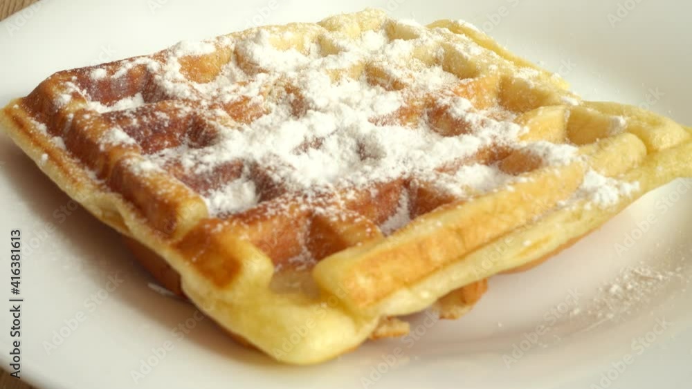Preparation of waffles. Waffles are sprinkled with powdered sugar. Preparation of waffles. Waffles are sprinkled with powdered sugar.