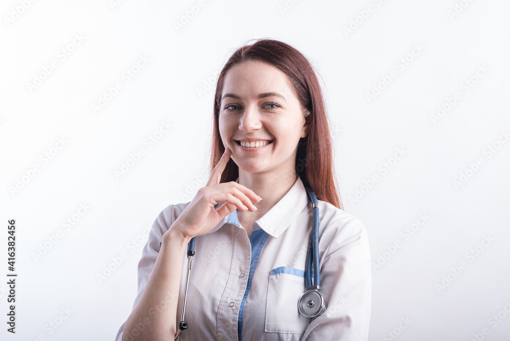 Portrait of a female doctor in a white uniform who thinks in the studio on a white background Portrait of a female doctor in a white uniform who thinks in the studio on a white background
