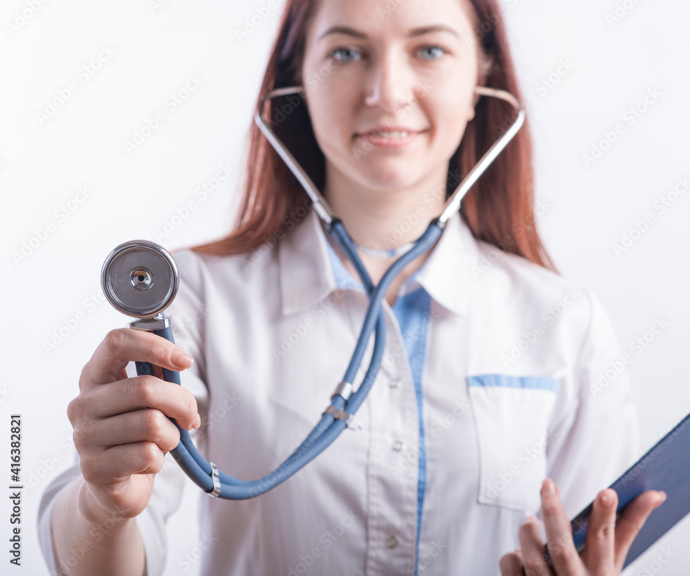 Portrait of a female doctor in a white uniform who is ready to work with a stethoscope in the studio on a white background Portrait of a female doctor in a white uniform who is ready to work with a stethoscope in the studio on a white background